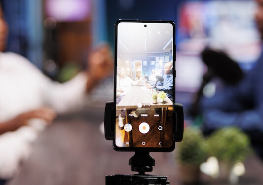 Smartphone on tripod records influencer