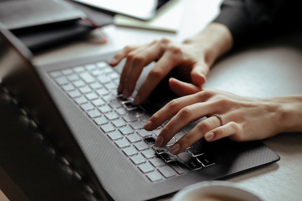 Working from home on the computer. Woman hands on computer.