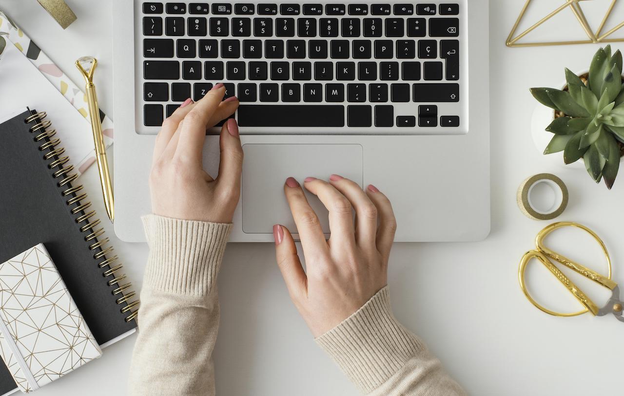 Dłonie kobiety piszące strategię publikacji na LinkedIn